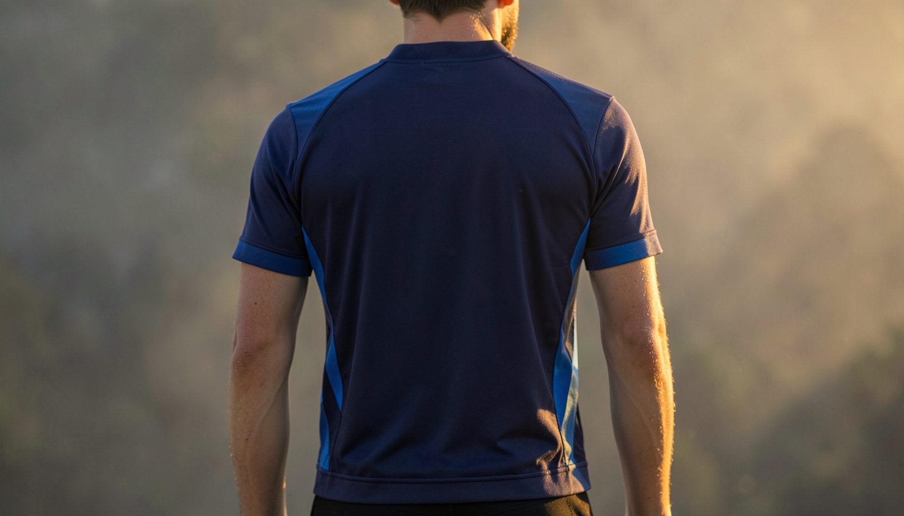 Rear view of a cycling jersey with three rear pockets, navy and blue tones, against a muted backdrop